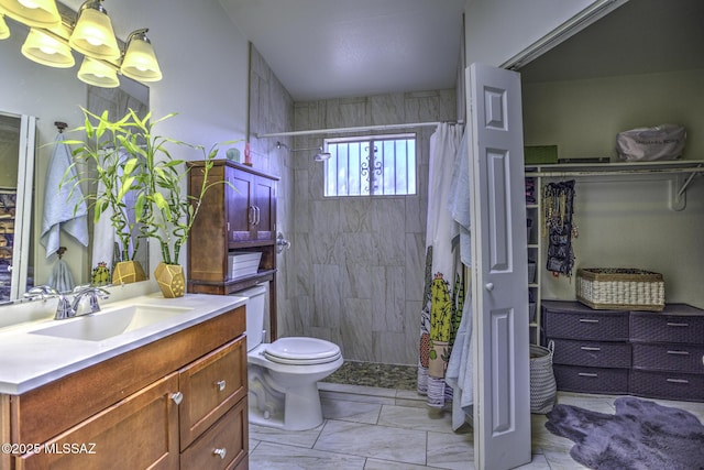 full bath featuring vanity, toilet, marble finish floor, and a tile shower