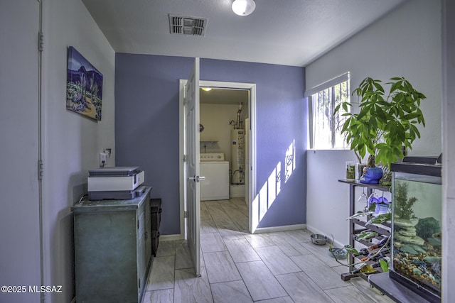 bathroom with washer / dryer, baseboards, visible vents, and water heater