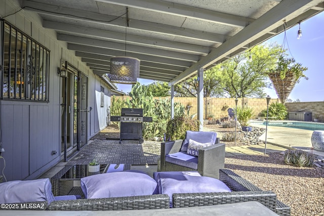 view of patio with an outdoor living space, a fenced in pool, a grill, and a fenced backyard