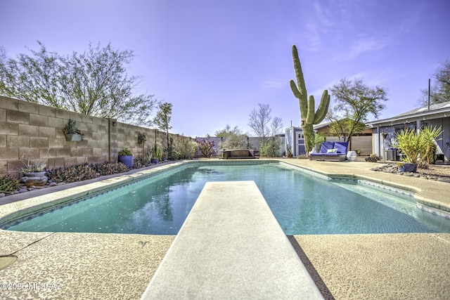 view of pool featuring a patio area, a fenced in pool, a fenced backyard, and a diving board