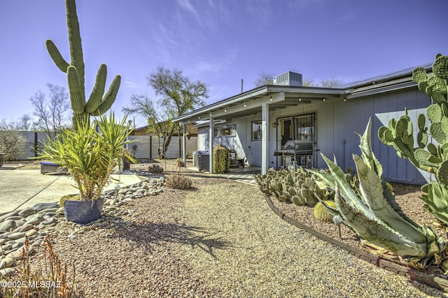 back of property with a patio area, central air condition unit, solar panels, and fence