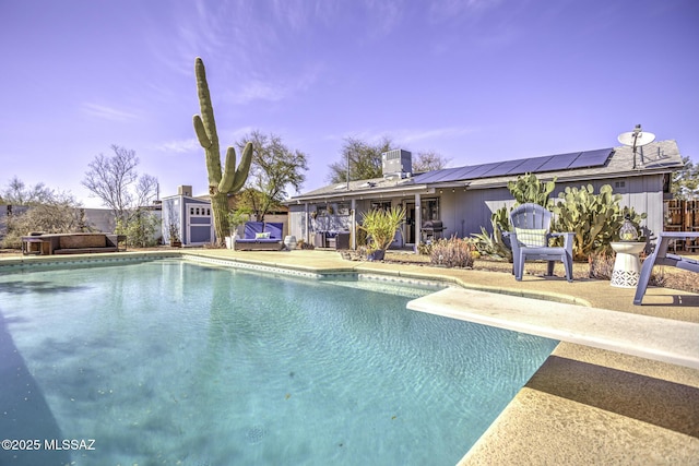 view of swimming pool with a diving board, an outdoor structure, a storage shed, central air condition unit, and a patio area