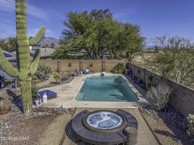 view of pool featuring an in ground hot tub, a fenced backyard, a fenced in pool, and a patio