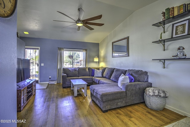 living room with vaulted ceiling, baseboards, ceiling fan, and wood finished floors