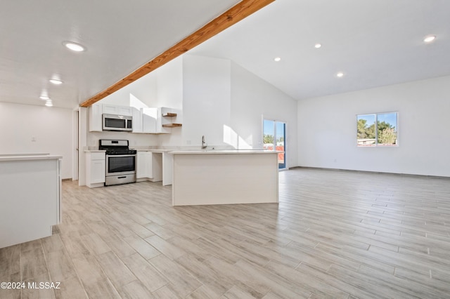 kitchen with light hardwood / wood-style flooring, appliances with stainless steel finishes, beam ceiling, high vaulted ceiling, and white cabinets