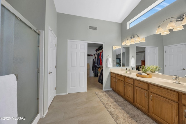 bathroom with an enclosed shower, vanity, tile patterned floors, and high vaulted ceiling