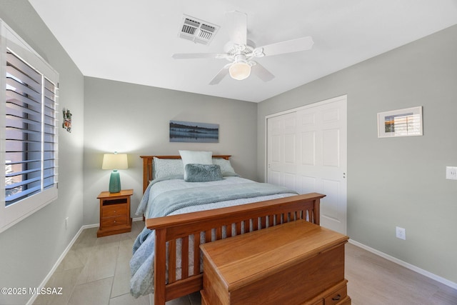 bedroom featuring multiple windows, ceiling fan, and a closet