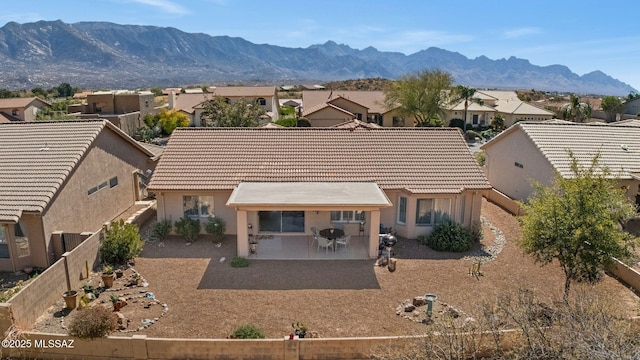 rear view of house with a mountain view and a patio area