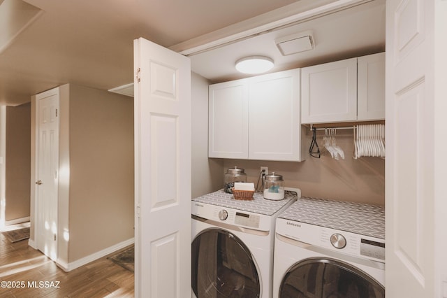 washroom with cabinets, washer and dryer, and light wood-type flooring