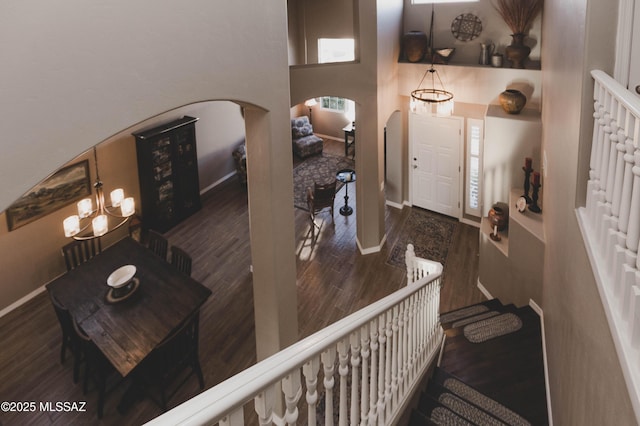 entryway with dark wood-type flooring and a towering ceiling