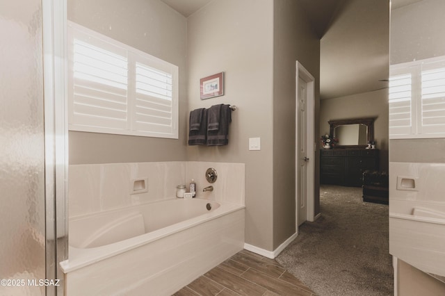 bathroom with hardwood / wood-style flooring and a tub