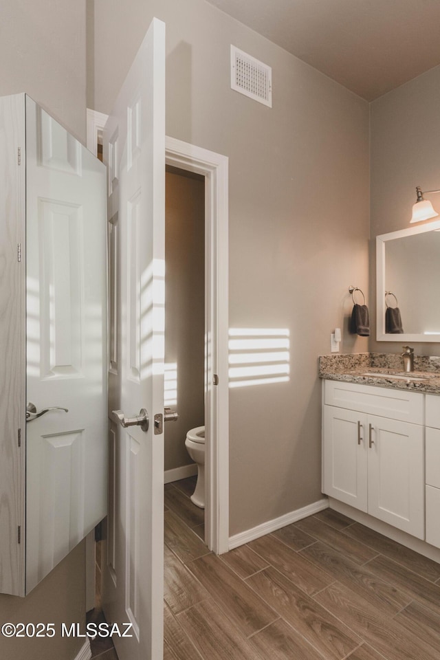 bathroom featuring vanity and toilet