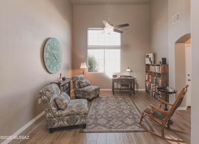 sitting room with ceiling fan and a towering ceiling