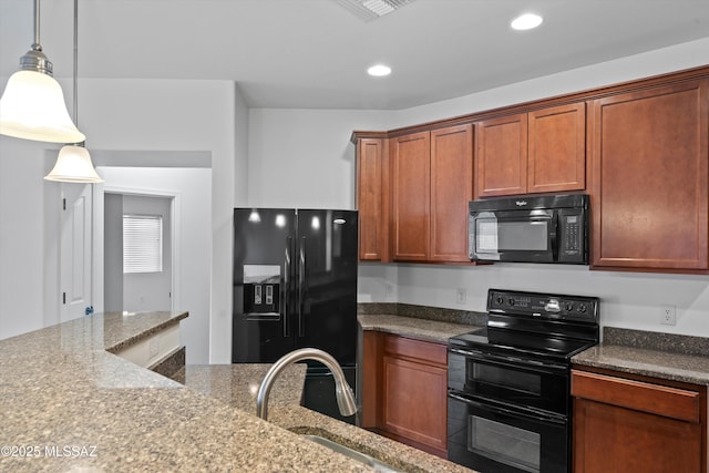 kitchen featuring light stone counters, decorative light fixtures, sink, and black appliances