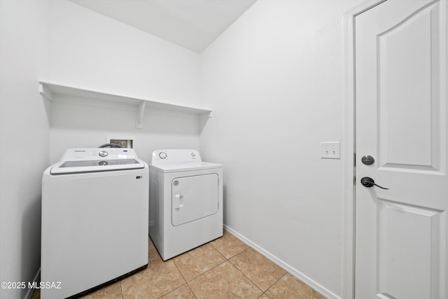 laundry area featuring washing machine and dryer and light tile patterned flooring