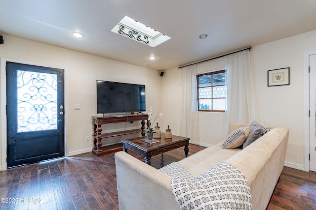 living room featuring a skylight, baseboards, dark wood finished floors, and recessed lighting