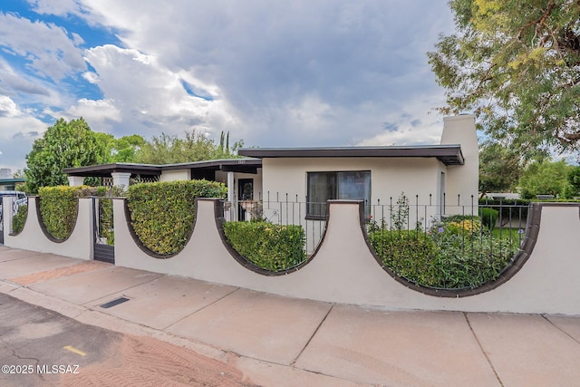 view of front of property featuring a fenced front yard and stucco siding