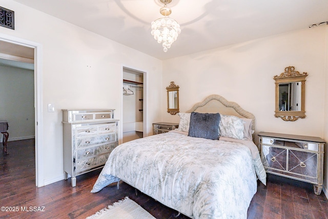 bedroom featuring dark wood-type flooring, a chandelier, and baseboards