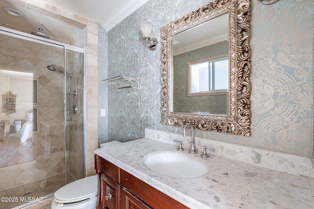 full bathroom with toilet, vanity, wallpapered walls, a stall shower, and crown molding