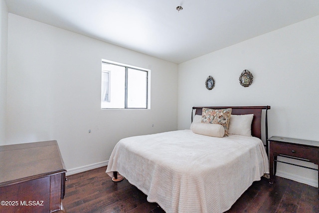 bedroom featuring baseboards and dark wood finished floors