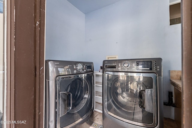 laundry area featuring washing machine and clothes dryer, tile patterned floors, and laundry area