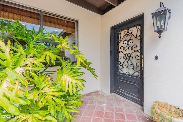 doorway to property featuring stucco siding