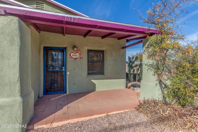 doorway to property featuring stucco siding