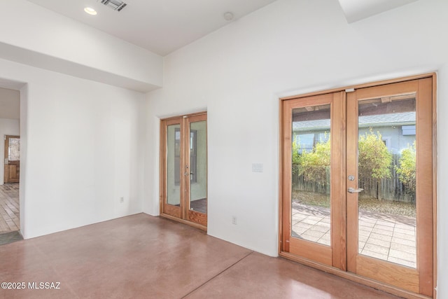 empty room featuring concrete floors and french doors