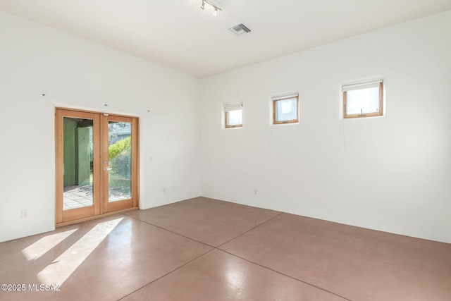 spare room with french doors and concrete floors