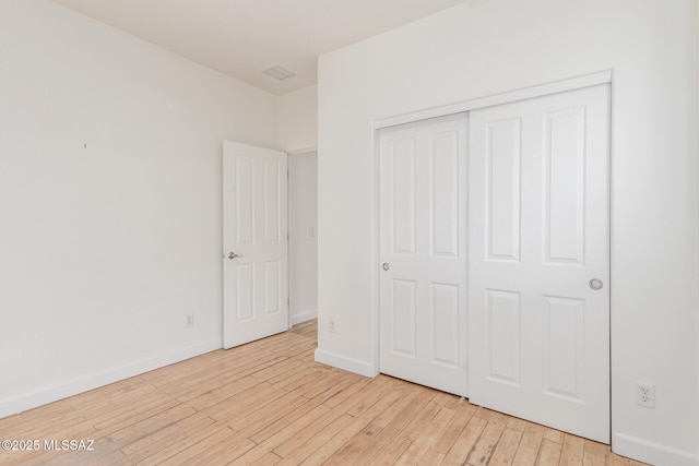 unfurnished bedroom featuring a closet and light wood-type flooring