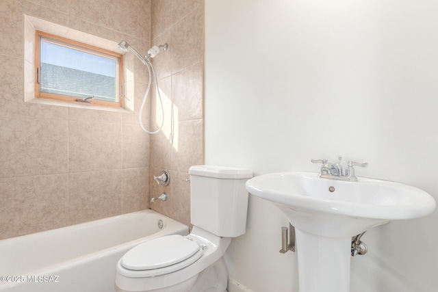 full bathroom featuring sink, tiled shower / bath combo, and toilet