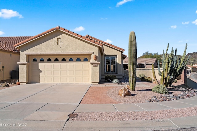 view of front of home with a garage and central AC unit