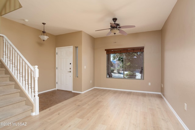 foyer featuring stairs, wood finished floors, and baseboards