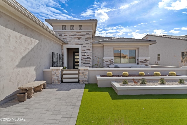 rear view of property with stone siding and stucco siding