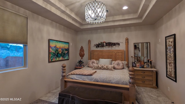 bedroom featuring a chandelier and a raised ceiling