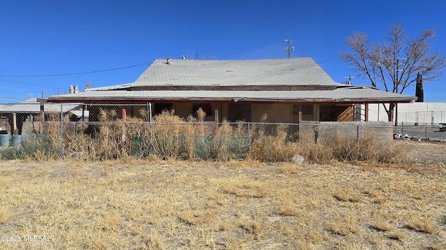 rear view of house featuring fence