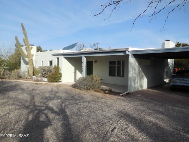 pueblo-style home featuring a carport