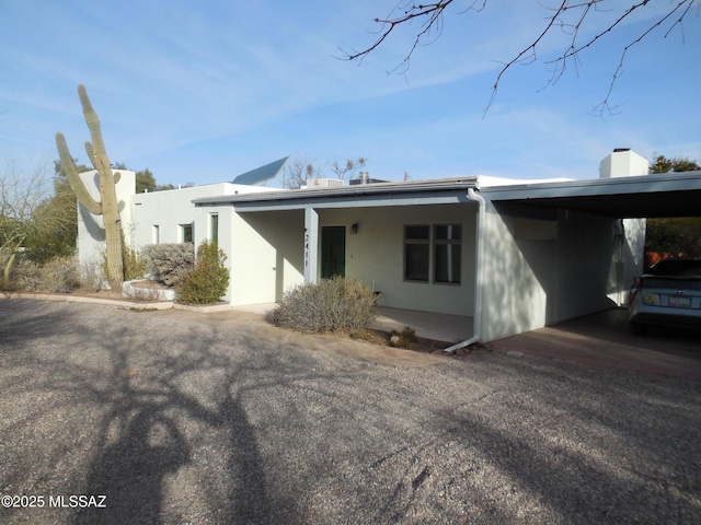 view of front of home with an attached carport and stucco siding