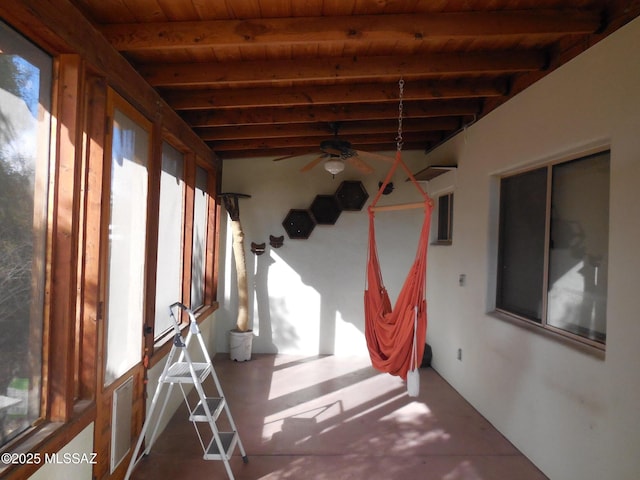 unfurnished sunroom featuring wooden ceiling, beamed ceiling, and ceiling fan