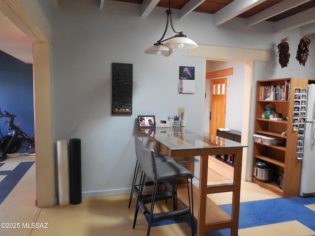 dining room with beam ceiling and baseboards