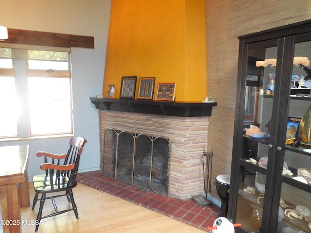 living area featuring a healthy amount of sunlight, a fireplace, and wood finished floors