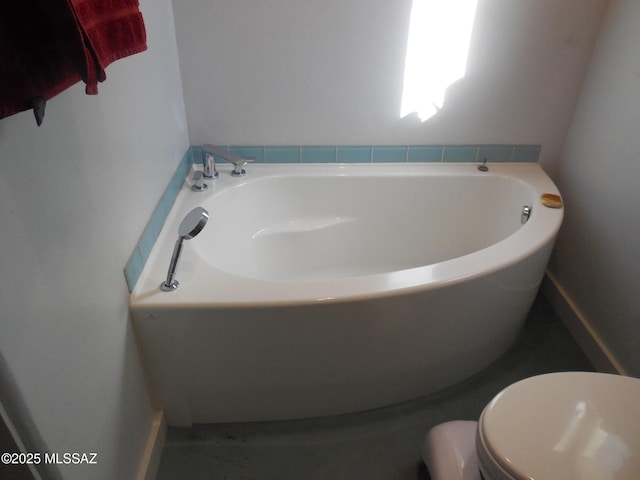 full bath featuring a garden tub and toilet