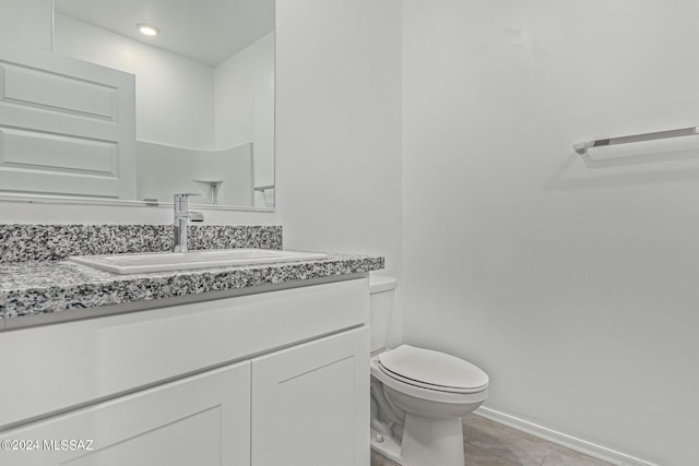 bathroom with vanity, toilet, and tile patterned flooring