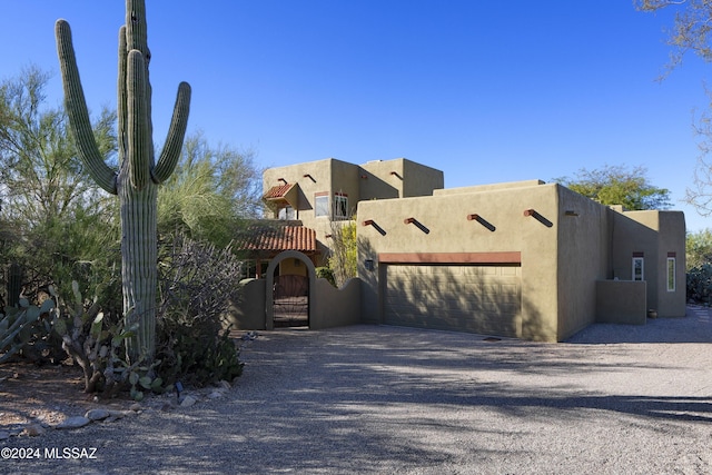 pueblo-style house featuring a garage