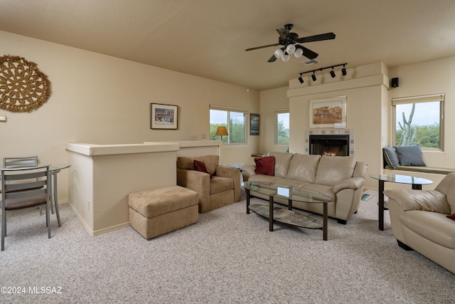 carpeted living room featuring a fireplace, ceiling fan, and track lighting