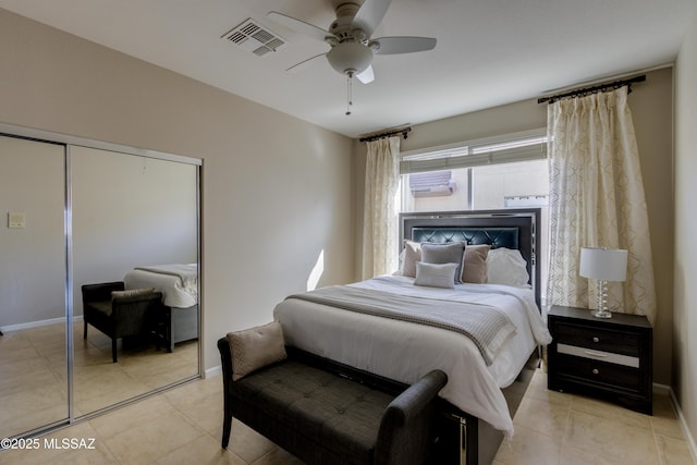 bedroom featuring light tile patterned flooring, ceiling fan, and a closet