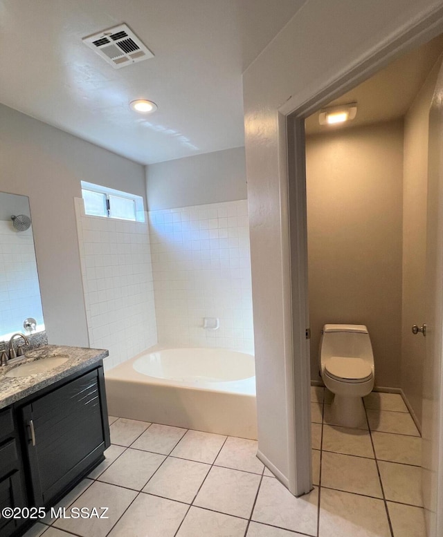 bathroom featuring visible vents, toilet, tile patterned flooring, a washtub, and vanity