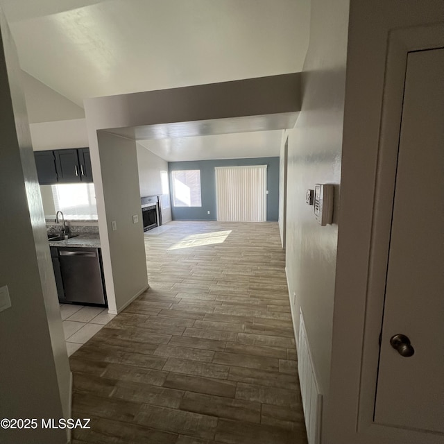 hallway featuring light wood finished floors and a sink