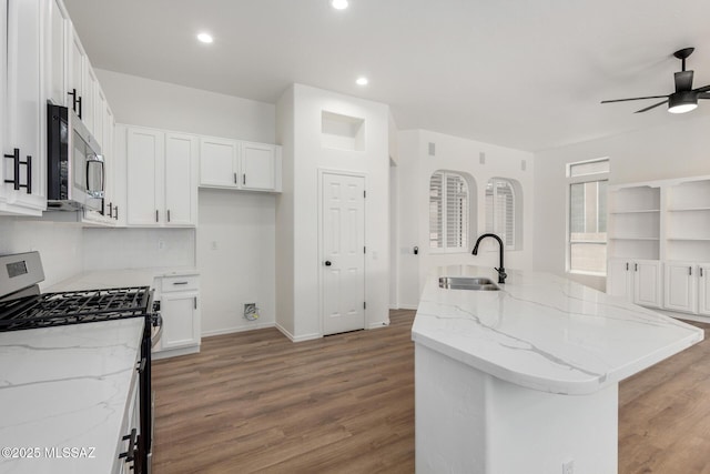 kitchen with a center island with sink, sink, stainless steel appliances, and white cabinetry