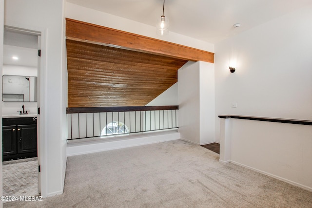 additional living space featuring vaulted ceiling, sink, and light carpet